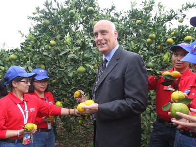 沃爾瑪中國公司事務高級副總裁博睿（中）考察大理項目基地，并同沃爾瑪員工志愿者一起幫助受助農戶收獲成熟的柑橘。